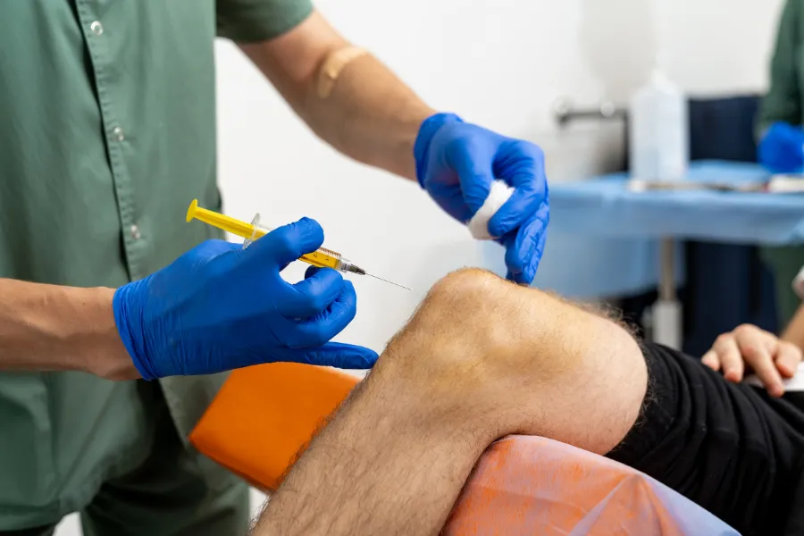 Doctor performing a Steroid Injection to patients knee